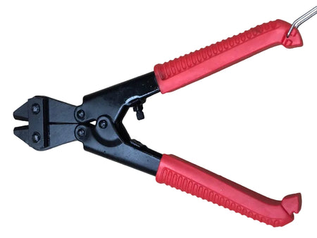 Pair of wire cutters with red handles on a beige surface
